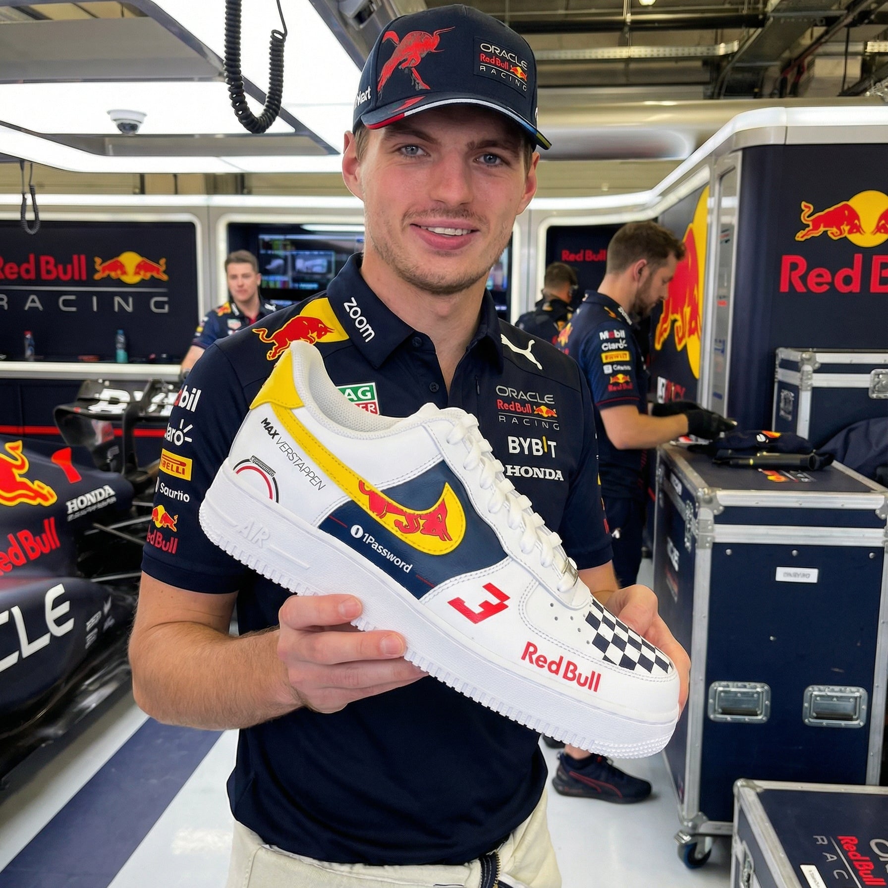 Max Verstappen holding a custom hand painted Red Bull racing shoe in a Red Bull F1 paddock